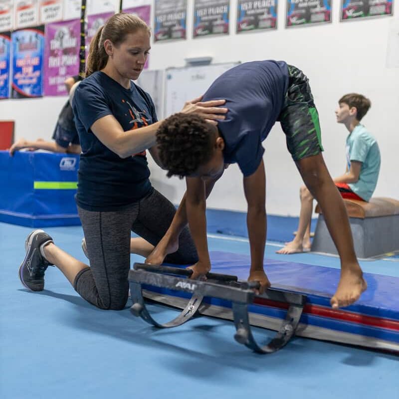 Lara Kay spotting a gymnast on beam